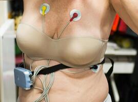 Caucasian womman wearing holter monitor device for daily monitoring of heart. photo