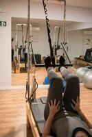 Woman training session with a reformer bed photo