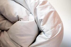 White folded featherduvet in a house. photo