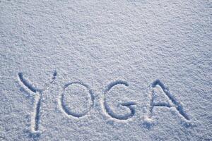 yoga en naturaleza. un inscripción en el nieve. el palabra yoga es escrito en el nieve. un minimalista imagen de zen budismo. paz y calma foto