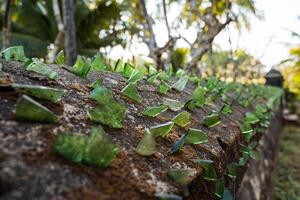 Abstract frame. Pieces of green glass are glued to the textured fence. Protection of the territory. photo