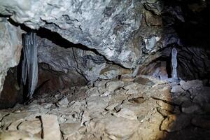 cueva subterráneo. hielo estalagmita en un oscuro cueva. profundo subterráneo oculto tesoro. hielo frío oscuro piedras silencio de profundidad foto