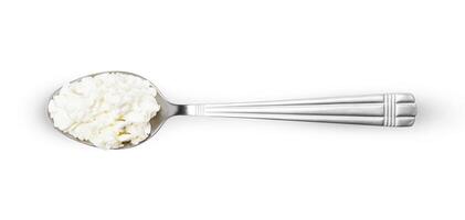 Cottage cheese in spoon isolated on white background photo