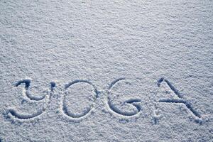 Yoga in winter. An inscription on the snow. The word yoga is written in the snow. a minimalist picture of Zen Buddhism. Peace and tranquility. photo