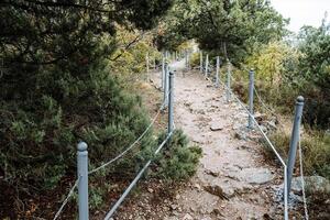 el montaña camino es cercado con un hierro cerca. caminar a el cima. frío en naturaleza. alpinismo para principiantes foto