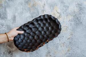 a large dark oval platter with interesting abstract pattern photo