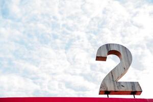 Two. Number two. A large wooden sign in the form of the number Two is installed on the roof. Signage against the backdrop of an incredible beautiful cloudy sky. photo