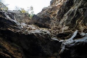 The surface of a large rocky cave, sharp protrusions and the texture of natural stone. Active holidays in the mountains, breathtaking nature photo