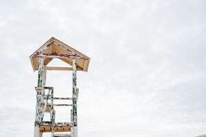 An old observation tower against the sky. Beach lifeguard booth. Equipment on the beach. Inspection of the territory from a height. photo