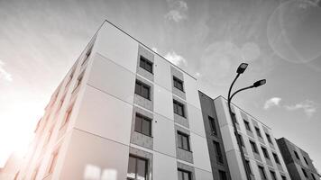 Fragment of the building's facade with windows and balconies. Modern apartment buildings on a sunny day. Facade of a modern residential building. Black and white. photo