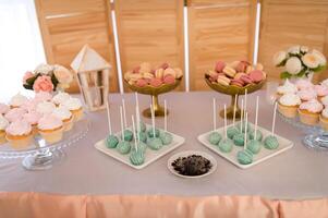 Dessert table with muffins, biscuits, macaroons, capcakes on a wooden background. Food photosession. photo