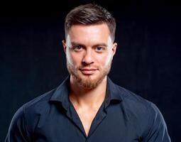 Portrait of smiling muscular man. Sexual muscular man posing over background photo