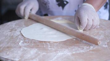 Hand rolling dough with rolling pin on wooden table video