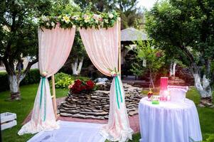 Arch for the wedding ceremony. Decorated with crystal chandelier and fresh flowers. Wedding decorations. The newlyweds photo