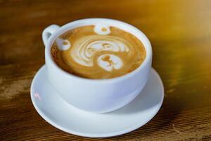 beautiful pattern in the form of bear in a white cup with a latte maded in the restaurant. Close-up photo