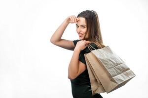 compras y estilo de vida concepto. joven alegre mujer participación compras pantalones conmovedor su frente. aislado terminado blanco antecedentes. foto