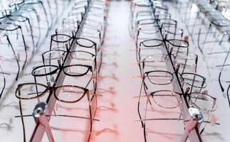 Eyeglasses in a store. Modern designed eyeglasses rims in a row photo