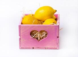 ripe lemon in wooden box isolated on white photo