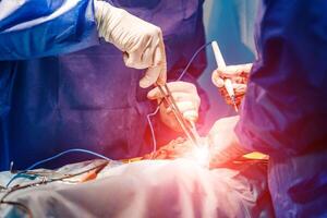 Team surgeon at work in operating room. Closeup of doctors' hands. Process of surgery operation using medical equipment. photo