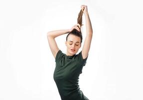 Beautiful brunet woman with her hands up to the hair with closed eyes. Portrait of a dreamy cute woman in black t-shirt with eyes closed isolated on white background. photo