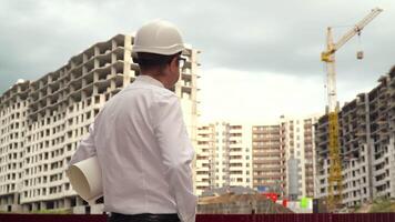 mannetje bouwer ingenieur architect in moeilijk hoed lezing blauwdruk Aan bouw plaats. gebouw bouw concept video