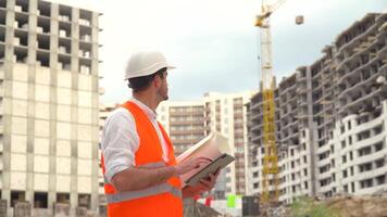 Architect or engineer working, browsing building project of construction site with tablet. Digital technologies in building construction video