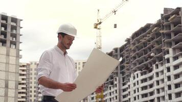 arquitecto o ingeniero laboral, hojeada edificio proyecto de construcción sitio con Plano plan video