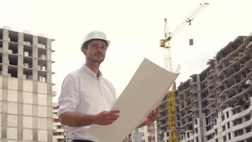 arquitecto o ingeniero trabajando en difícil sombrero hojeada edificio proyecto de construcción sitio con Plano plan video