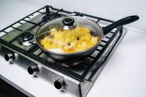 frying potatoes in a pan with oil, top view photo