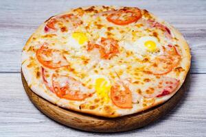 Hot Pizza Served On Old Table. Delicious pizza served on wooden plate photo