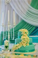 Wedding cake in turquoise-white colors. Wedding table with candles photo