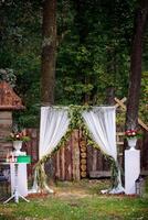 arco para el Boda ceremonia. decorado con tela flores y verdor foto