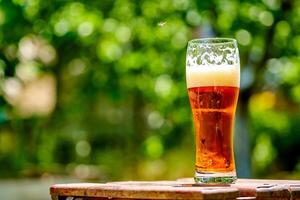 Cold beer on wooden table in the garden photo