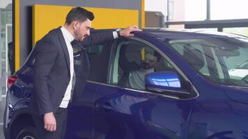 elegante hombre inspecciona un nuevo coche a un coche concesión video