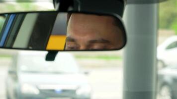 Bearded man looks in the rearview mirror in the car. Auto business, car sale, technology and people concept video