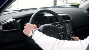 PARIS, FRANCE - MAY 15, 2020. A man in a new Renault model at a prestigious auto show. Auto business, car sale, video