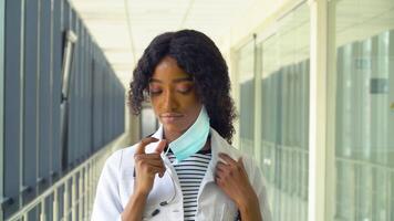 African american female doctor removes a medical mask in modern clinic. End of quarantine. Stop virus video