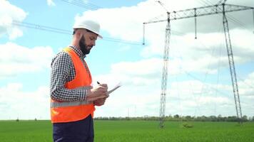 Engineer working near transmission lines. Electrical engineer checks high voltage lines. Transmission towers video