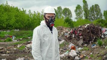 Activist scientist with respirator on landfill. Environmental pollution concept video