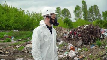 Activist scientist with respirator on landfill. Environmental pollution concept. Stop pollution video