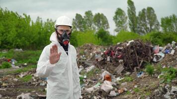 Activist scientist with protective mask on landfill. Environmental pollution concept. Stop pollution video