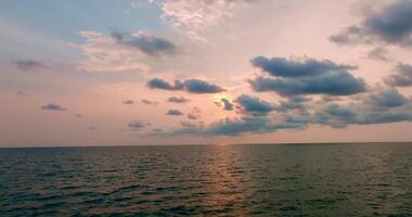 aéreo zumbido ver de claro turquesa mar y olas terminado el Oceano con puesta de sol video