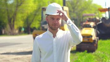 Manager of the repair works in a white helmet on the background of special road equipment video