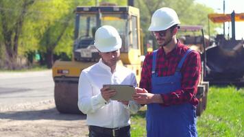 manager van de reparatie werken en arbeider Aan weg. weg manager shows arbeider weg bouw plan Aan een tablet. weg reparatie concept video