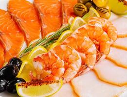 salmon, white fish, shrimps and olives close up photo