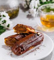 Tasty eclairs and cup of tea photo