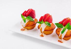 Vanilla cupcakes with strawberry on white plate photo