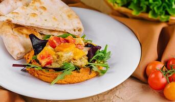 Creamy Lebanese Hummus and pepper rolls on plates photo