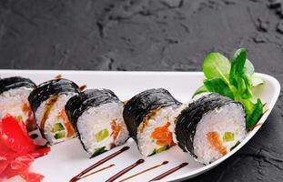 nori sushi rolls with salmon on plate photo