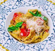 italiano pasta con Tomates, parmesano, albahaca foto